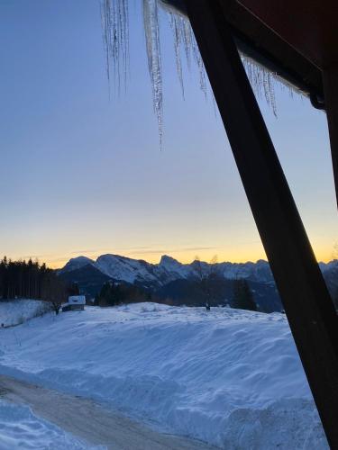 a view of a snow covered field with the mountains at Hotel Enzo Moro in Sùtrio