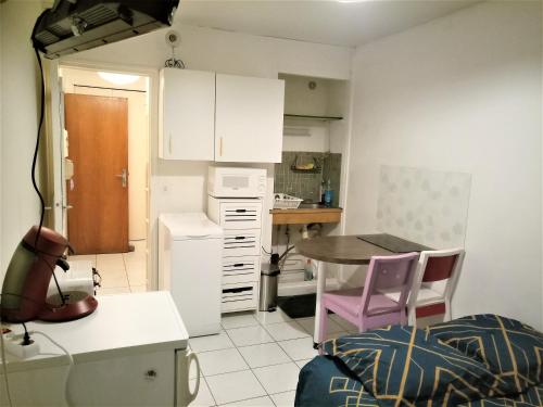 a small kitchen with a table and a purple chair at APPARTEMENT PROCHE GARE ET CENTRE VILLE in Melun