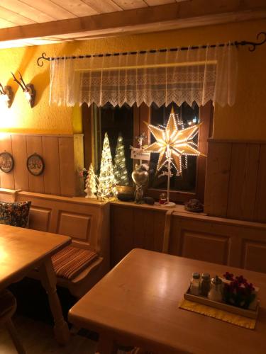a dining room with a christmas tree in a window at Maier Pension in Bayerisch Eisenstein