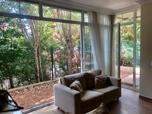 a living room with a couch in front of a large window at Lovely Escape House in a Frame with Garden in Istanbul