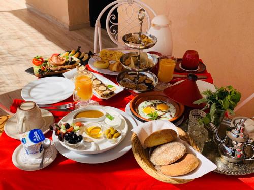 a breakfast table with breakfast foods on a red table cloth at Villa Kesh Evasion Marrakech in Marrakech