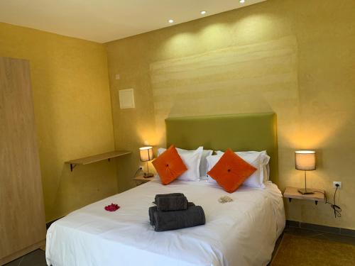 a bedroom with a large white bed with orange pillows at Villa Kesh Evasion Marrakech in Marrakech