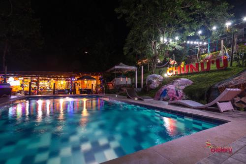 a swimming pool at night with chairs and lights at MINCA Chunuu - glamping - coworking MINCA in Minca