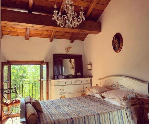 Dormitorio con cama con espejo y lámpara de araña en Agriturismo i Gessi en Calvignano