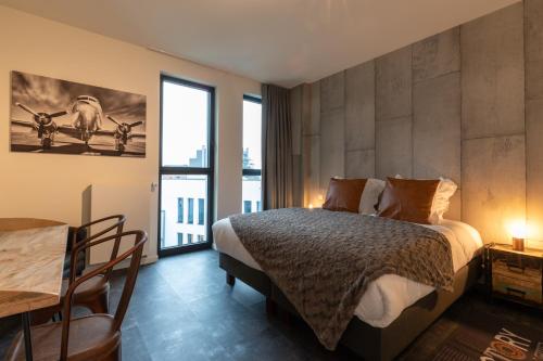 a bedroom with a bed and a large window at GUILLEMINS STATION FLATS in Liège