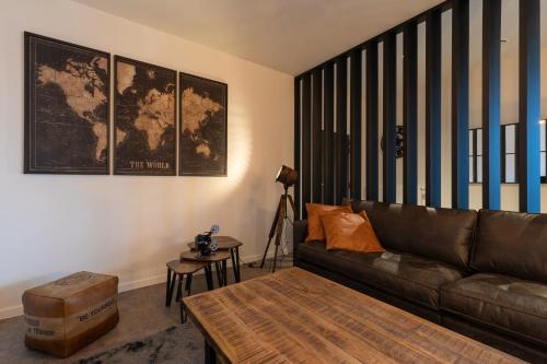 a living room with a brown couch and a table at GUILLEMINS STATION FLATS in Liège
