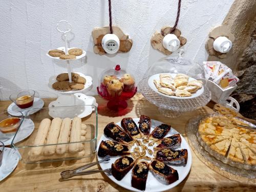 a table topped with plates of food and cookies at B&B Santu Giuvanni "Un tuffo nel passato Fonnese" in Fonni