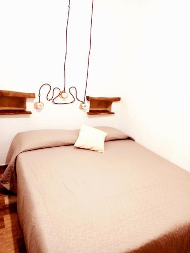 a bedroom with a bed and a chandelier at B&B Santu Giuvanni "Un tuffo nel passato Fonnese" in Fonni