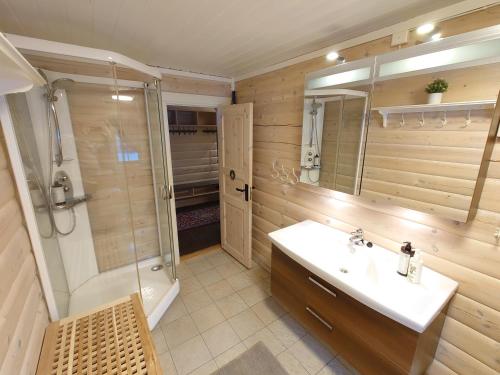 a bathroom with a sink and a shower and a mirror at 100m lift, 2 min swim - Large family cabin in Vradal