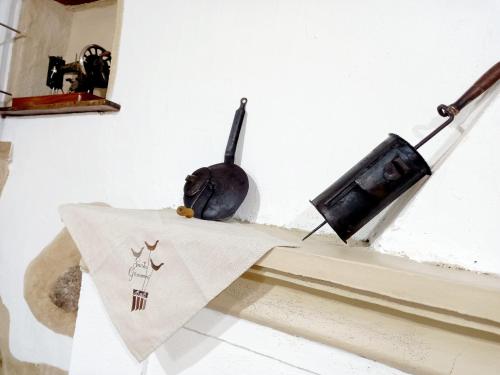 a table with a napkin and a television on a wall at B&B Santu Giuvanni "Un tuffo nel passato Fonnese" in Fonni