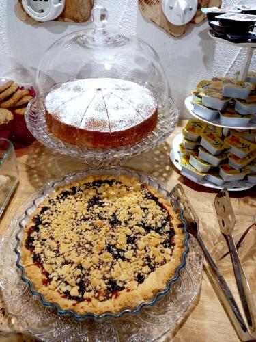 a table topped with a pie and other desserts at B&B Santu Giuvanni "Un tuffo nel passato Fonnese" in Fonni