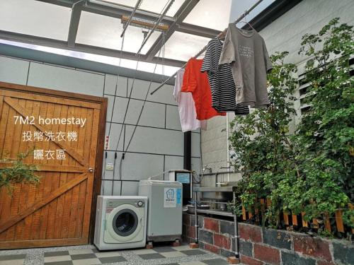 a washing machine and clothes hanging in front of a building at 7m2民宿 #免費停車 #慶修院 in Jian