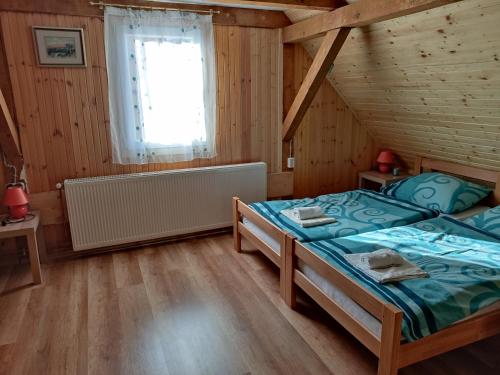 um quarto com 2 camas numa casa de madeira em Kuća za odmor "Seka"*** em Mrkopalj