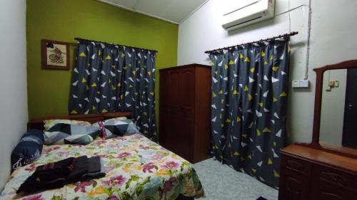 a bedroom with a bed and curtains with stars on them at Homestay Opah Parit Buntar, Perak in Parit Buntar