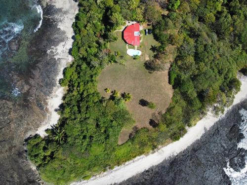 an aerial view of an island with a red house and the ocean at Casa Don Marcos in Playa Azul
