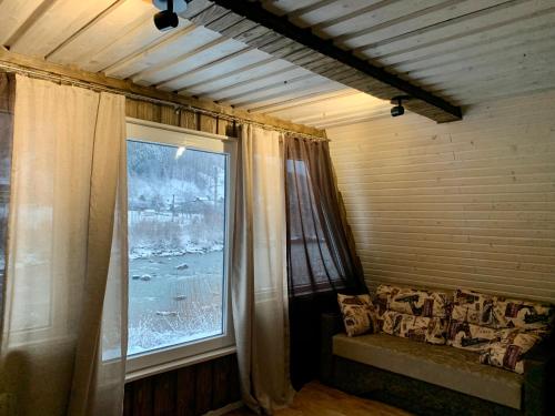 a living room with a couch and a large window at VIP-Domyk in Rakhiv