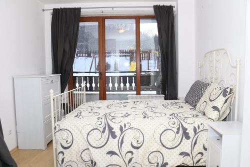 a bedroom with a bed and a window at 50m from Ski Piste 1 BR Apartment in Predela 2 in Bansko