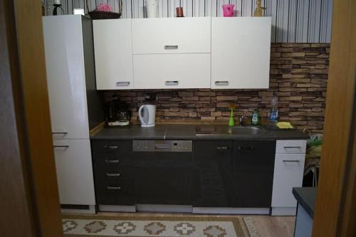a kitchen with white cabinets and a sink at Ferienwohnung auf dem Dach des Frankenwaldes in Schwarzenbach am Wald