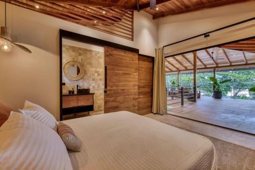 um quarto com uma cama grande e uma janela grande em Yoshi's on the beach em Cahuita