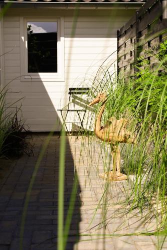 a bird statue sitting in front of a house at Studio Mañana in Cuijk