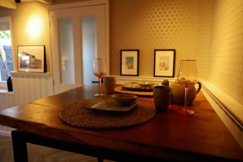 drewniany stół z dwoma kieliszkami wina w obiekcie B&B Mañana w mieście Cuijk