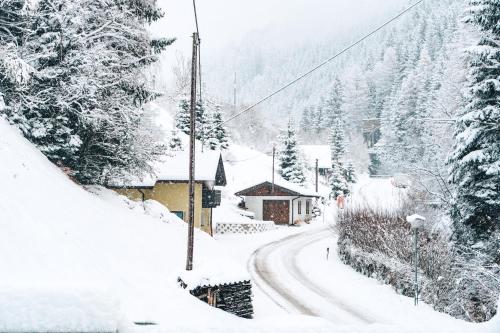 a snow covered street with a building and trees at Ferienhaus Leite Häusl in Sankt Jodok am Brenner