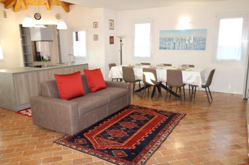 a living room with a couch and a dining table at Casa al Piave - appartamento a 5 km dal mare in Eraclea