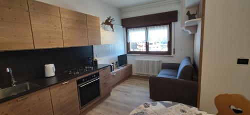 a kitchen with wooden cabinets and a stove top oven at Genzianella in Tarvisio