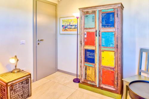 una camera con una porta a vetri colorata e un tavolo di Appartamenti Ortensia Golfo Aranci a Golfo Aranci