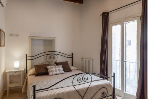 a bedroom with a bed and a large window at Albergo Diffuso Monopoli in Monopoli