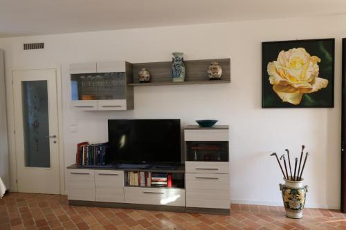 a living room with a flat screen tv on a entertainment center at Casa al Piave - appartamento a 5 km dal mare in Eraclea