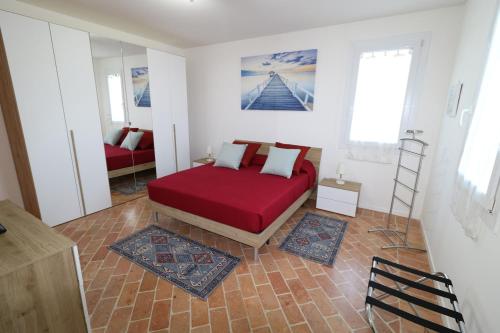 a bedroom with a red bed and a ladder at Casa al Piave - appartamento a 5 km dal mare in Eraclea