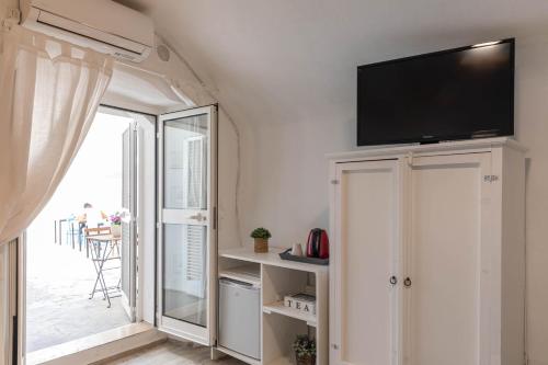 a living room with a flat screen tv on a wall at Albergo Diffuso Monopoli in Monopoli