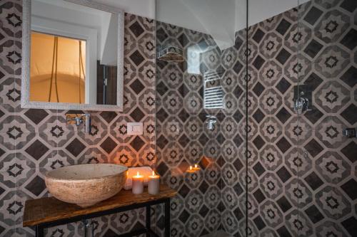 a bathroom with a sink and a mirror and candles at Albergo Diffuso Monopoli in Monopoli