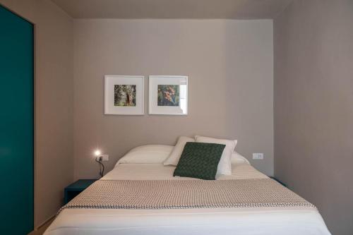 a bed in a bedroom with two pictures on the wall at Albergo Diffuso Monopoli in Monopoli