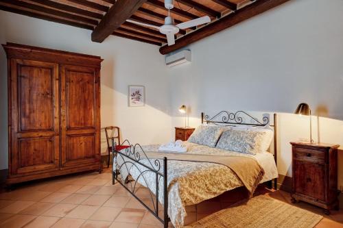 モンテプルチャーノにあるTenuta Golo Luxury Villa - Wine Estate with Pool near Montepulcianoのベッドと木製のキャビネットのある寝室
