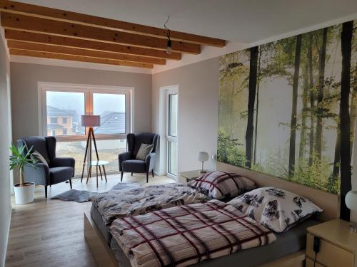 a bedroom with a bed and two chairs at Beim Eifelfranken in Darscheid