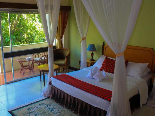 a bedroom with a bed with a canopy at Equator Hotel in Arusha