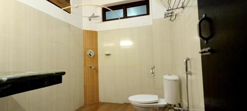 baño con aseo y ventana en Le Coxy Resort Lachung en Lachung