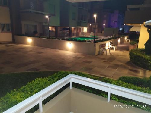 uitzicht op een zwembad in de nacht bij Apartamento Capão Novo in Capão da Canoa