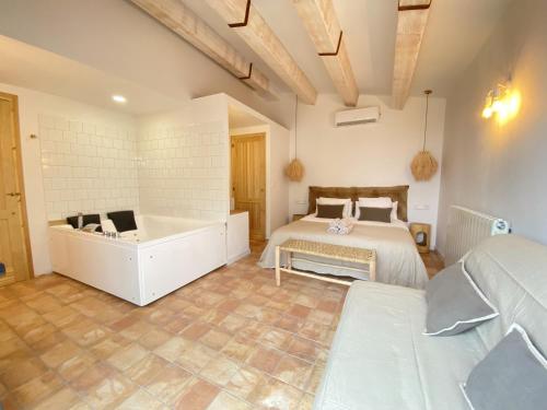 a bedroom with two beds and a bath tub at Mas de l'Aranyó - Eco Wellness Spa in Hostafranco