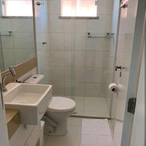 a bathroom with a toilet and a sink and a shower at Apartamento na Praia do Saco - Condomínio Villa das Águas in Estância