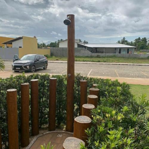 a fence with a car parked in a parking lot at Apartamento na Praia do Saco - Condomínio Villa das Águas in Estância