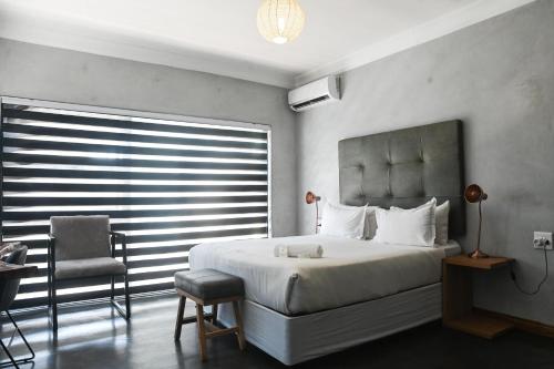 - une chambre avec un lit, une chaise et une fenêtre dans l'établissement ANISA GUESTHOUSE, à Thohoyandou