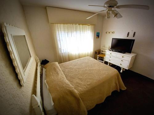 1 dormitorio con 1 cama y TV de pantalla plana en Punta del Este frente al mar, 2 ambientes en Playa Mansa Parada 9, Edificio Paracas, en Punta del Este