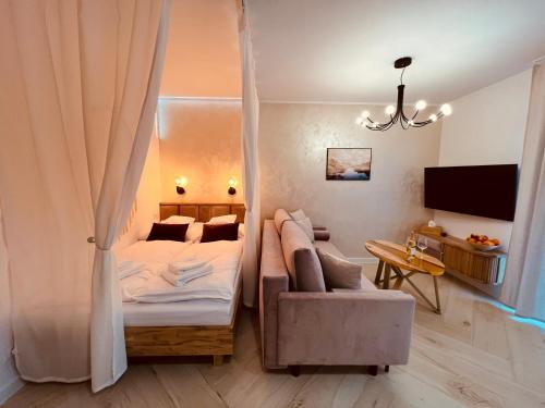 um quarto com uma cama, um sofá e uma televisão em Sunset Apart em Jelenia Góra