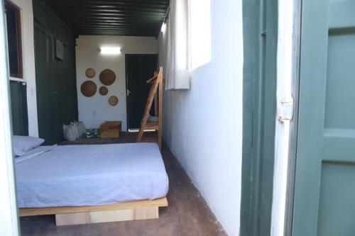 a small bedroom with a bed in a room at Zero Meia Um Pousada in São Miguel do Gostoso