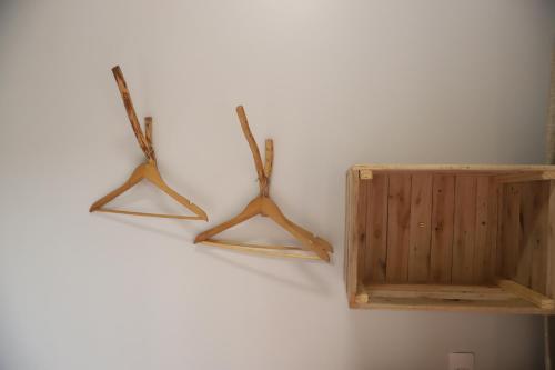 two wooden hangers are hanging on a wall at Zero Meia Um Pousada in São Miguel do Gostoso
