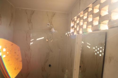 a bathroom with a shower with a glass door at Zero Meia Um Pousada in São Miguel do Gostoso