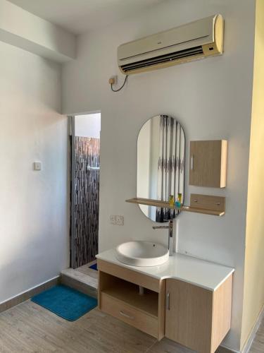 a bathroom with a sink and a mirror at Atrium Cottage in Seeduwa